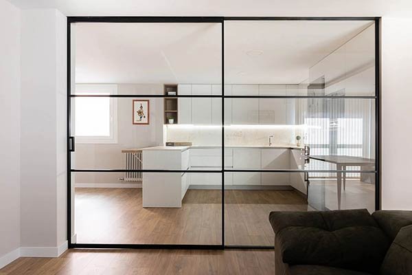 Cerramiento de cristal en cocina moderna con puertas correderas negras