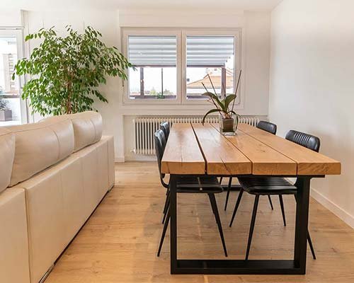 Comedor con ventanas y toldos exteriores visibles desde el interior