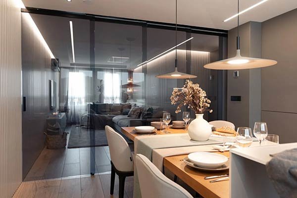 Cerramiento de cristal ahumado separando comedor y salón