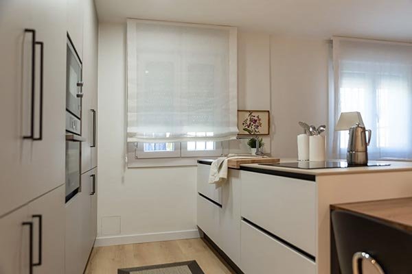 Cocina con ventana de PVC y persiana enrollable blanca translúcida bajada