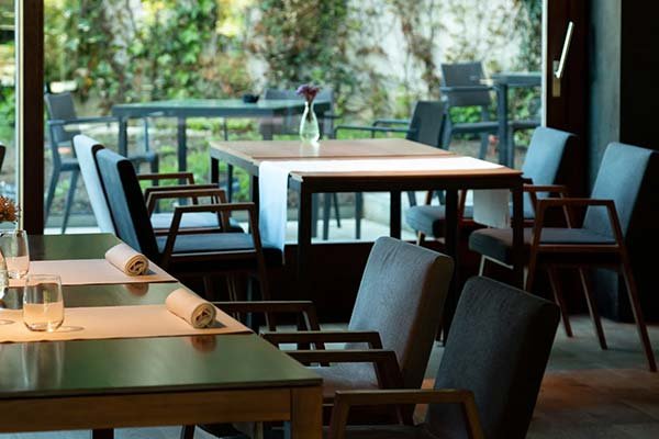 Restaurante con ventanales grandes y estores enrollables que controlan la luz natural